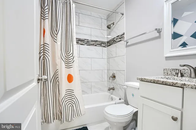 a bathroom with a sink a toilet and shower curtain