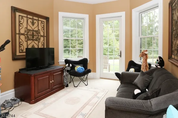 a living room with furniture and a flat screen tv with wooden floor