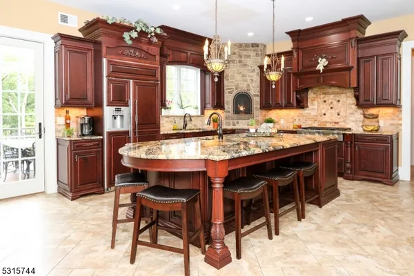 a kitchen with stainless steel appliances granite countertop a table chairs sink and cabinets