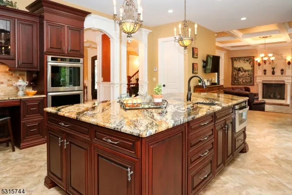a kitchen with stainless steel appliances granite countertop a sink a stove and a wooden cabinets
