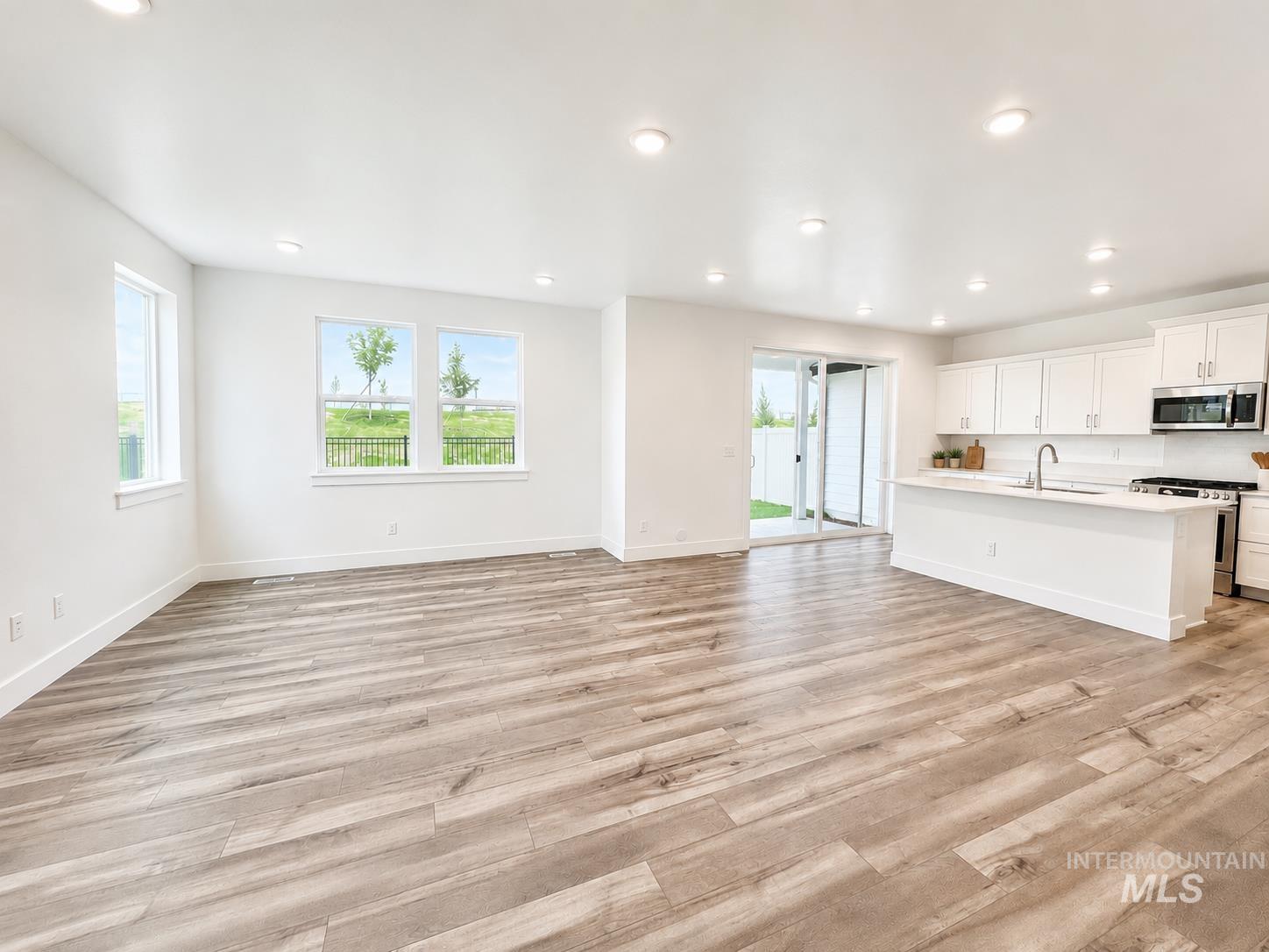 8098 West Fern Street Eagle, ID 83616 - Photo 3 of 22 Open-concept living space featuring wood-finish flooring, recessed lighting, and multiple windows