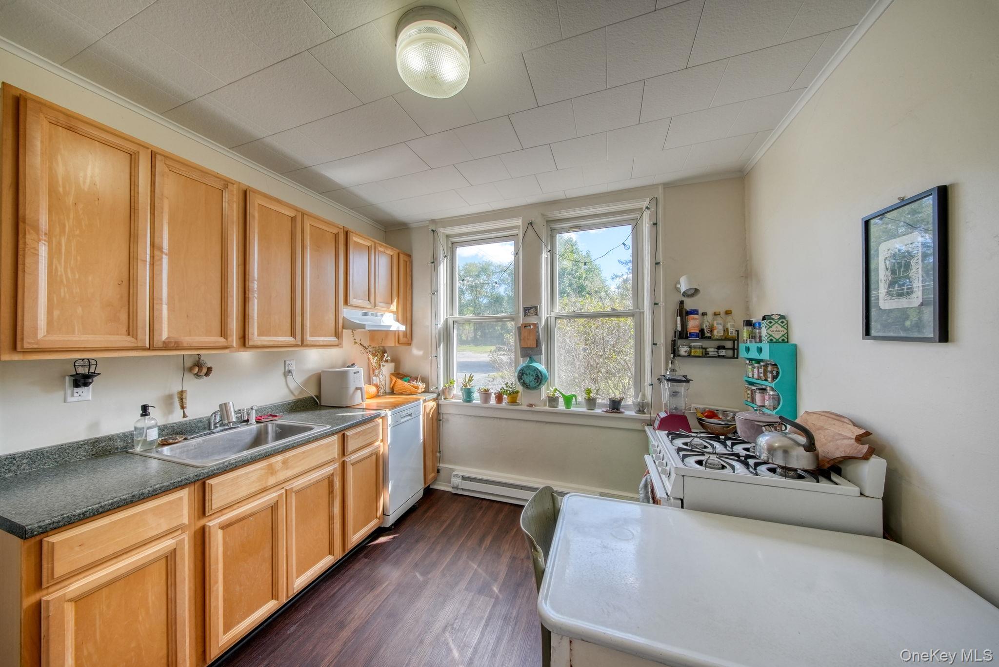 9 Mongaup Road Hurleyville, NY 12747 - Photo 13 of 35 Kitchen featuring ornamental molding, dark wood-type flooring, white appliances, light brown cabinetry, and under cabinet range hood