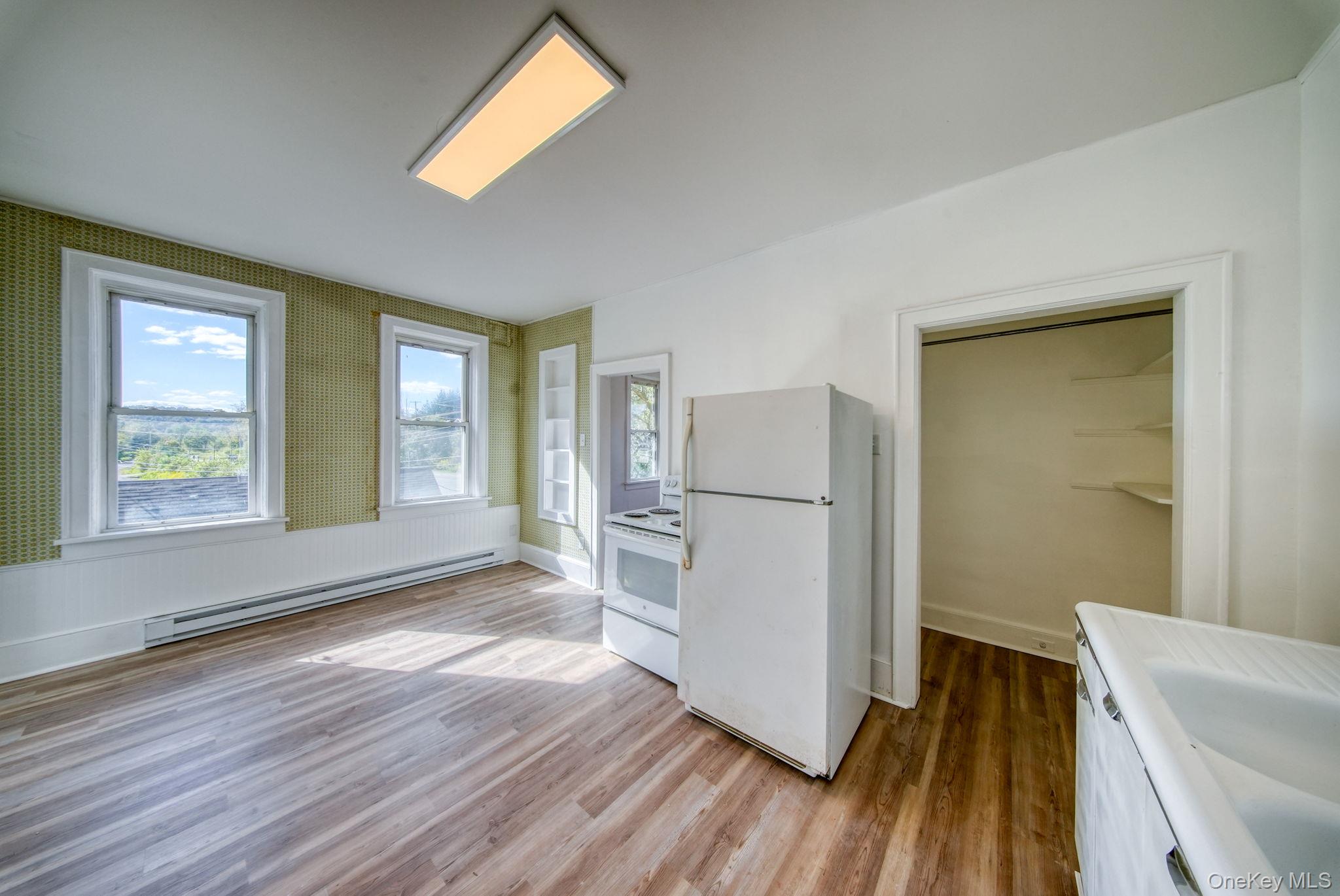 9 Mongaup Road Hurleyville, NY 12747 - Photo 27 of 35 Kitchen with white appliances, light wood finished floors, baseboard heating, and plenty of natural light