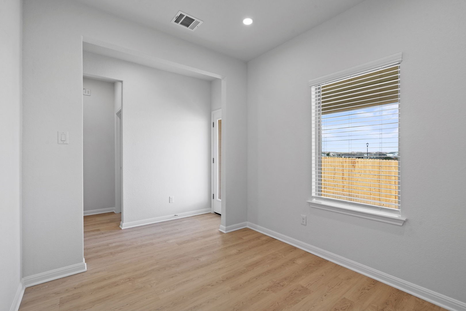 141 Hatari Trail Jarrell, TX 76537 - Photo 10 of 36 a view of an empty room with wooden floor and a window