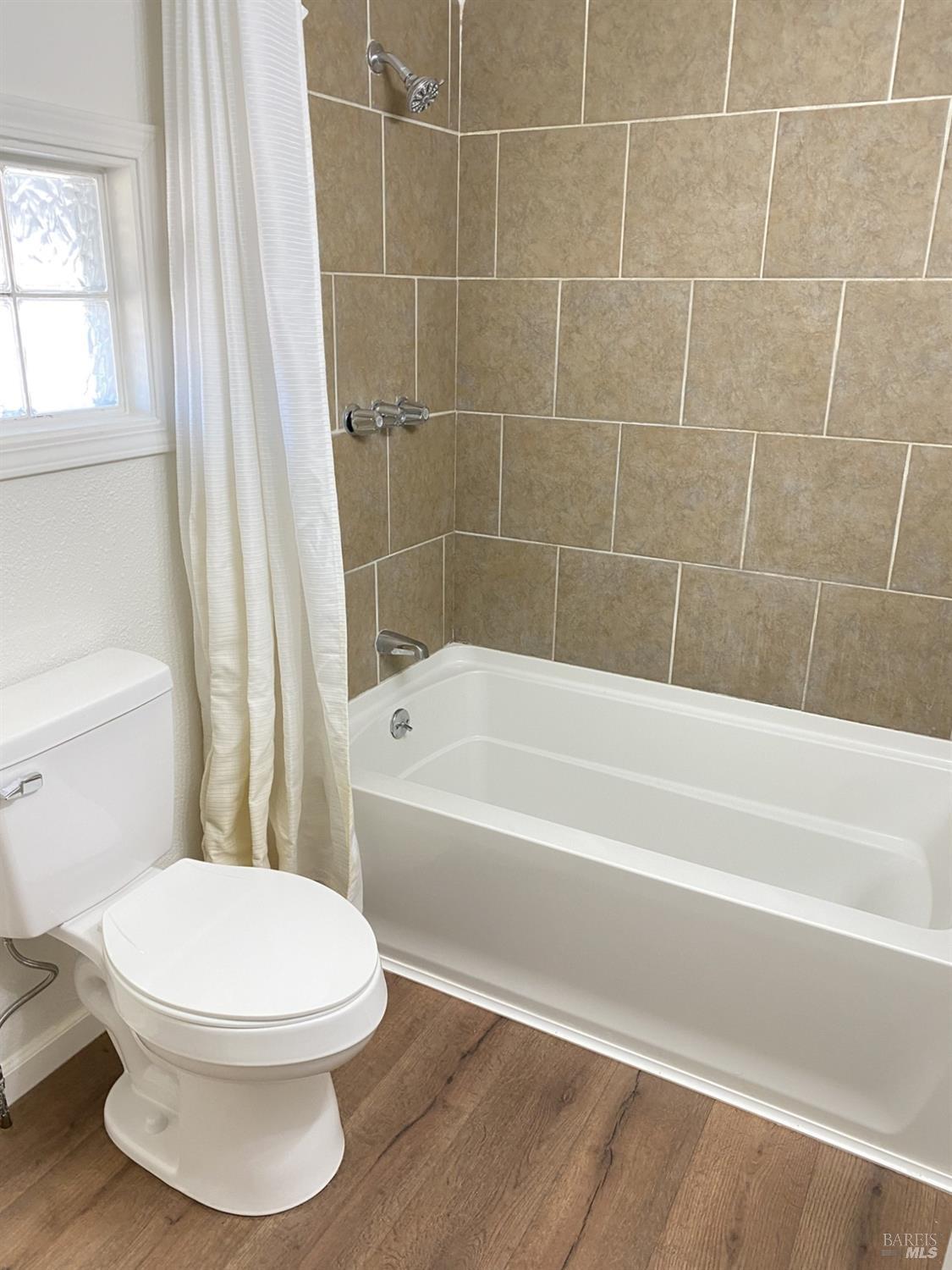 1047 Ohio Street Fairfield, CA 94533 - Photo 28 of 36 a white toilet and a bath tub sitting next to a window