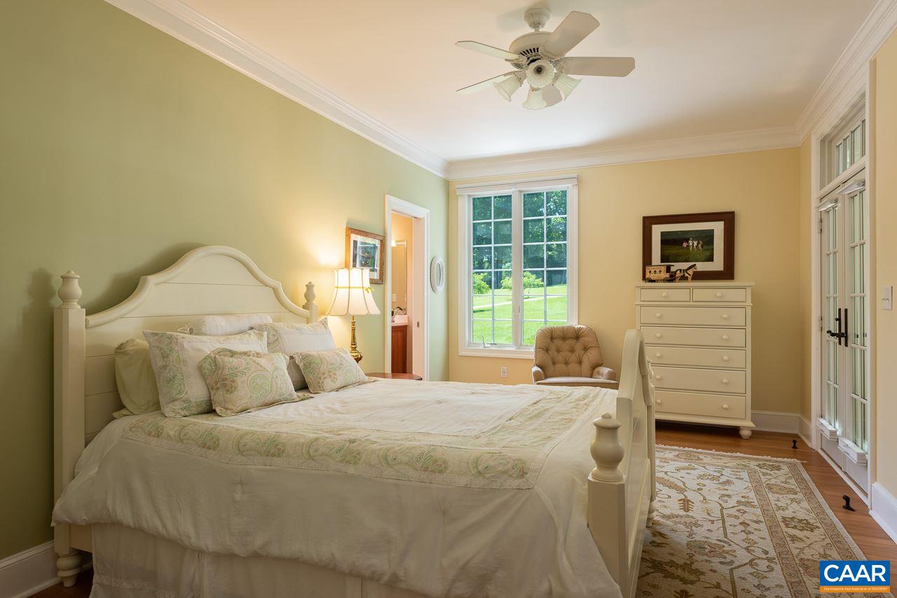 2274 Garth Road Charlottesville, VA 22901 - Photo 18 of 32 a bedroom with a bed and a chandelier