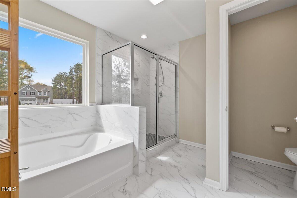 1237 Huffington Oak Drive Willow Spring, NC 27592 - Photo 22 of 34 a bathroom with a bathtub and a shower