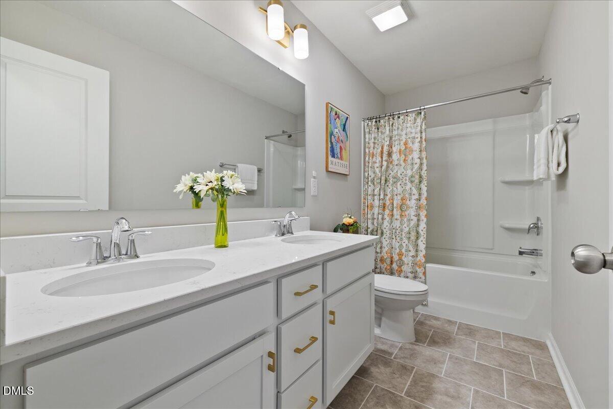 1237 Huffington Oak Drive Willow Spring, NC 27592 - Photo 27 of 34 a bathroom with a double vanity sink toilet and shower