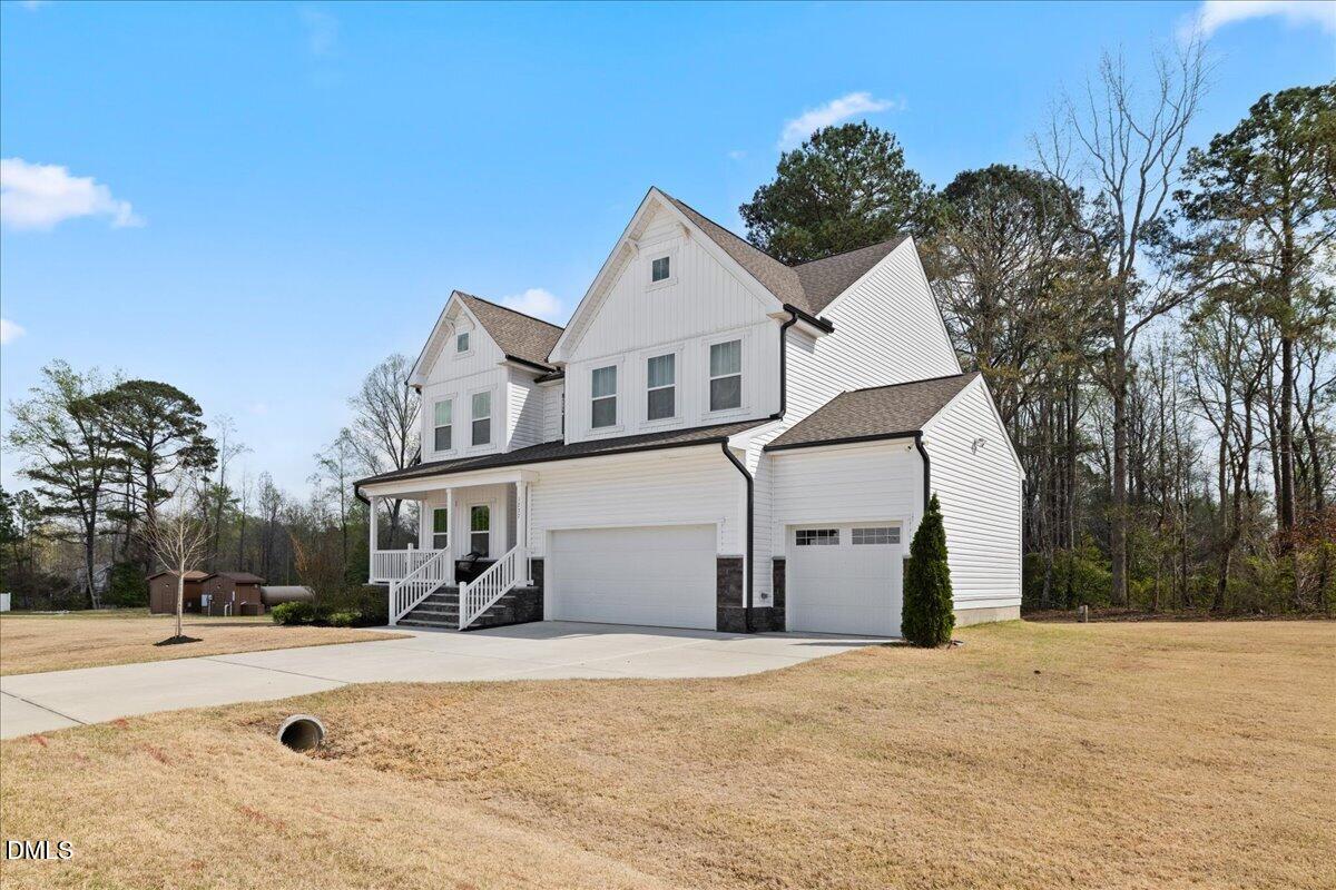 1237 Huffington Oak Drive Willow Spring, NC 27592 - Photo 3 of 34 a view of a white house with a yard and large trees