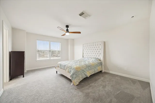 a spacious bedroom with a bed and a window