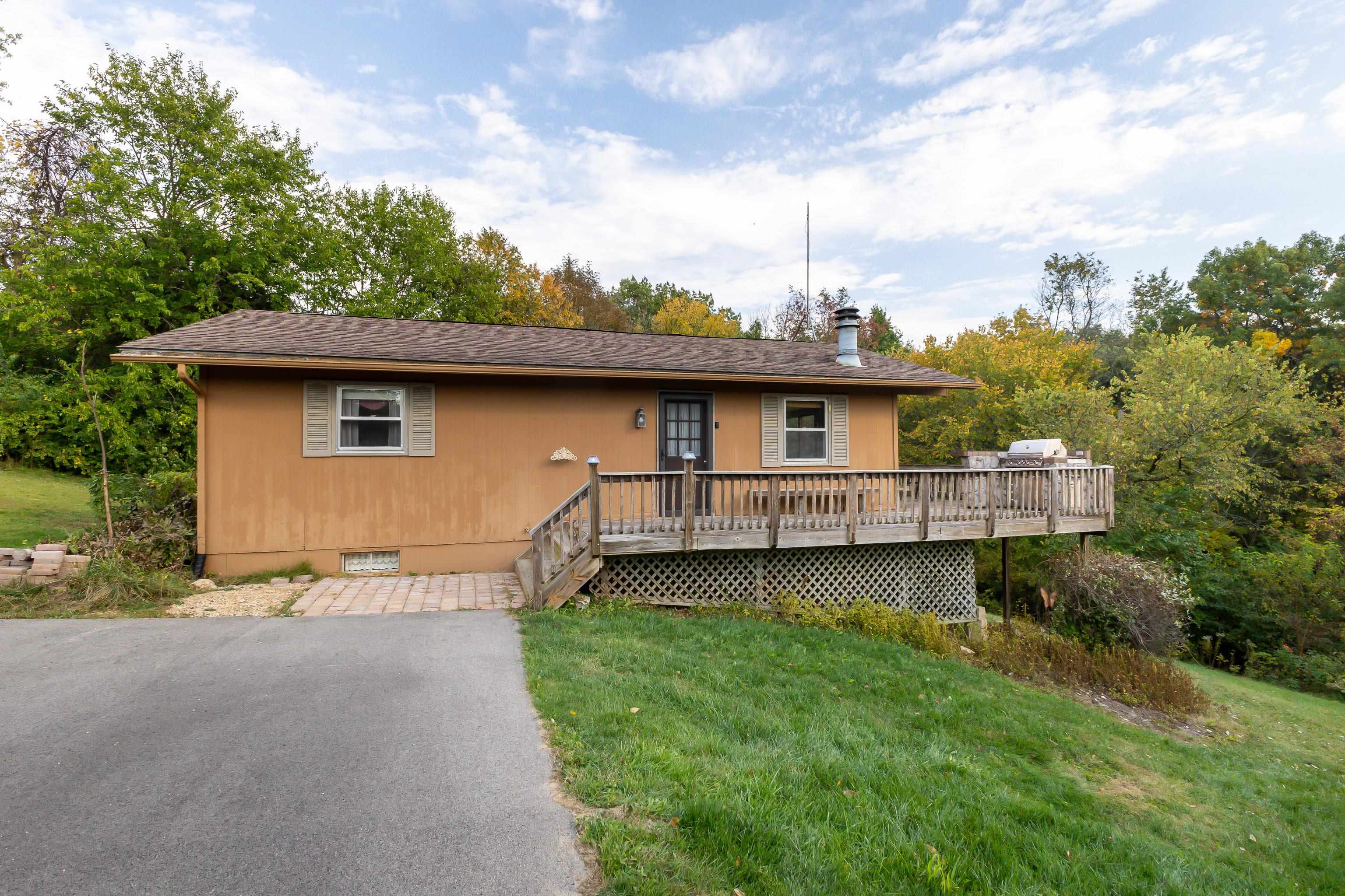 a backyard of a house with wooden deck and barbeque oven