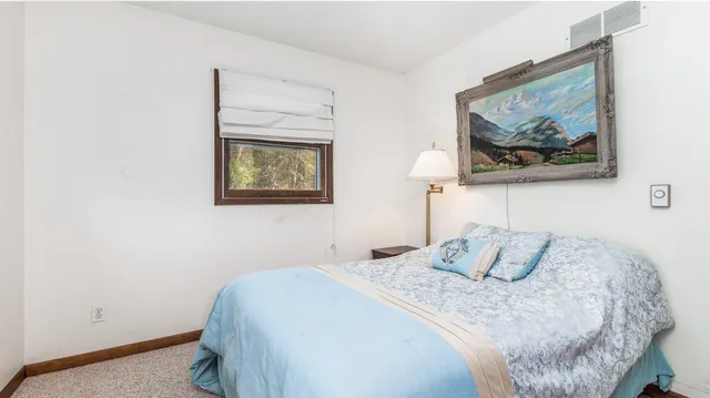 a bedroom with a bed and a painting on the wall