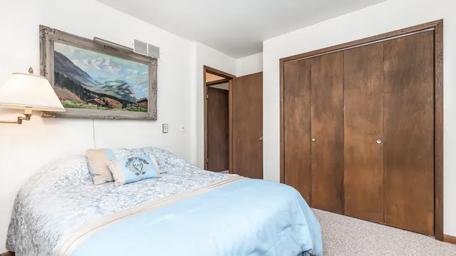 a bedroom with a bed and a painting on the wall