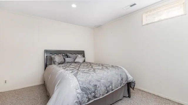 a bed sitting in a bedroom next to a window