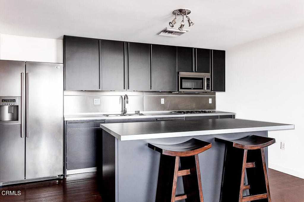 257 South Spring Street, Unit PHE Los Angeles, CA 90012 - Photo 17 of 32 a kitchen with a sink cabinets and stainless steel appliances