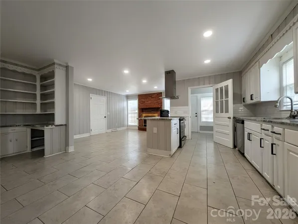 a large kitchen with stainless steel appliances kitchen island granite countertop a large cabinets and a counter top space