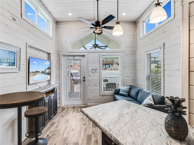 a kitchen with stainless steel appliances kitchen island granite countertop a table chairs in it and wooden floors