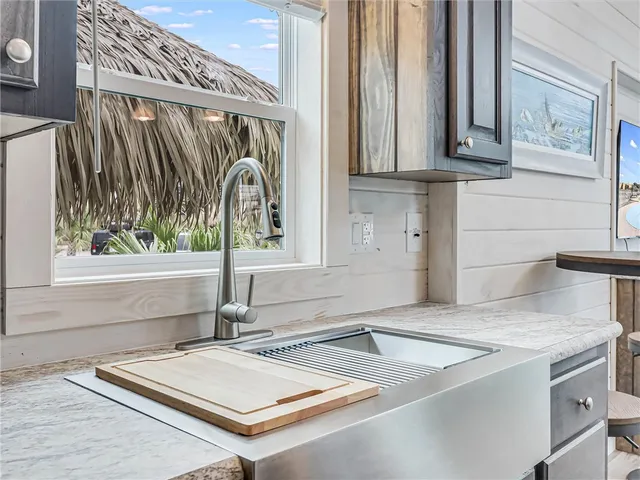 a view of a kitchen with kitchen island a sink wooden floor and a window