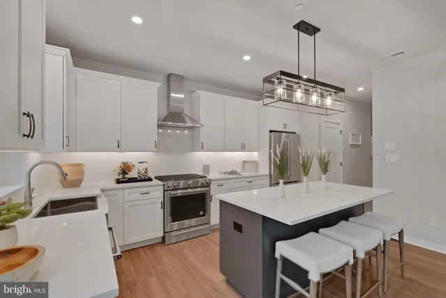 a kitchen with a stove a sink a dining table and chairs