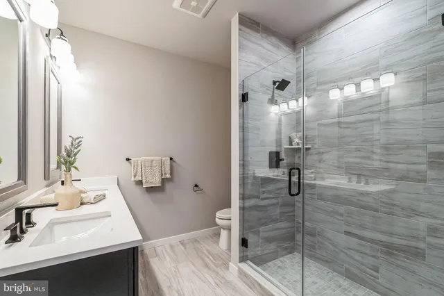 a bathroom with a sink a toilet and shower