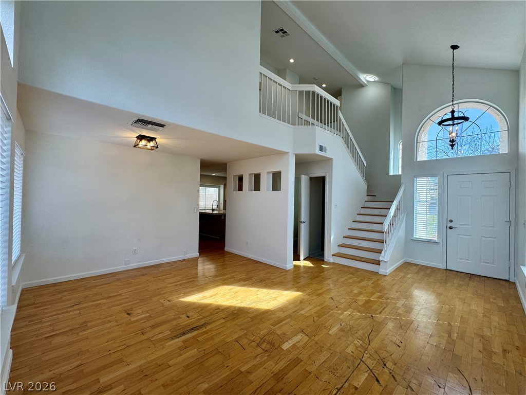 73 Sea Holly Way Henderson, NV 89074 - Photo 46 of 59 Foyer entrance featuring healthy amount of natural light, light wood-style floors, a high ceiling, and suspended lighting