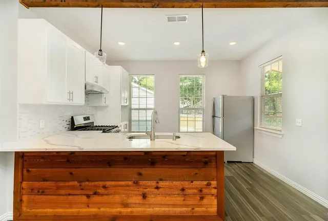a view of kitchen with stainless steel appliances granite countertop cabinets and wooden floor
