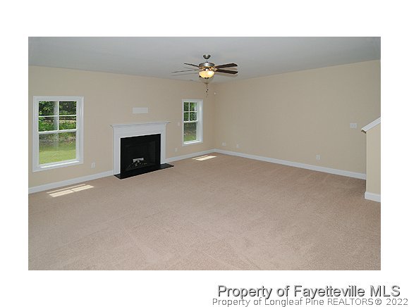 57 Ginseng Street Spring Lake, NC 28390 - Photo 5 of 25 a living room with a fireplace and a ceiling fan