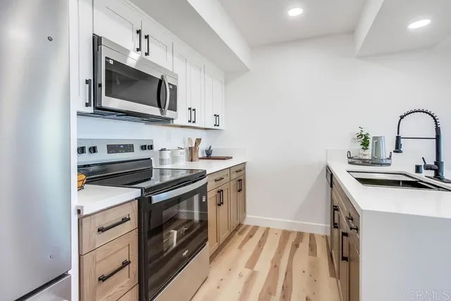 a kitchen with stainless steel appliances a stove microwave and sink
