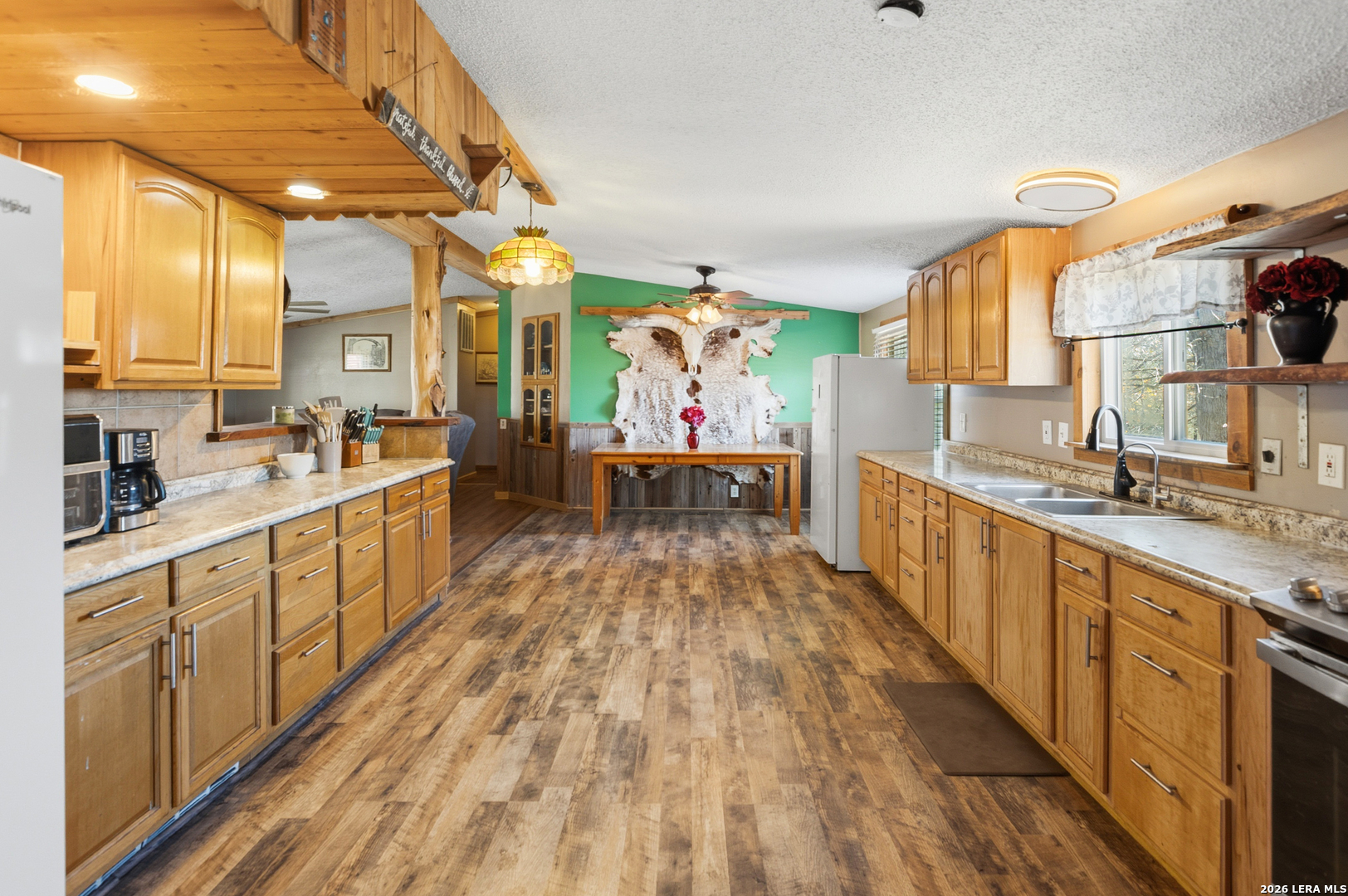 470 Lyon Road Seguin, TX 78155 - Photo 14 of 43 a large open kitchen with stainless steel appliances kitchen island granite countertop a sink and wooden floors