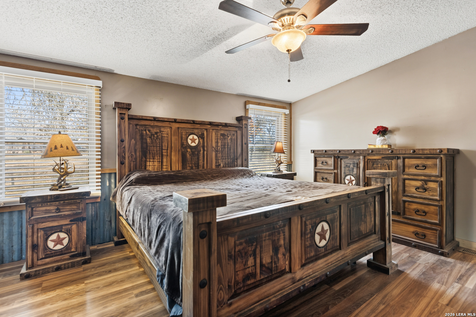 470 Lyon Road Seguin, TX 78155 - Photo 21 of 43 a bedroom with a bed a dresser and potted plants on the wooden floor