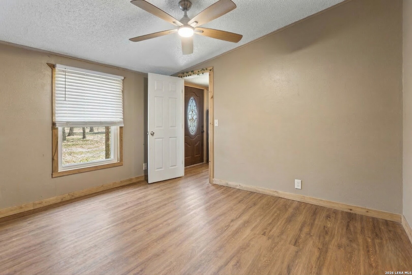 470 Lyon Road Seguin, TX 78155 - Photo 27 of 43 an empty room with wooden floor chandelier fan and windows