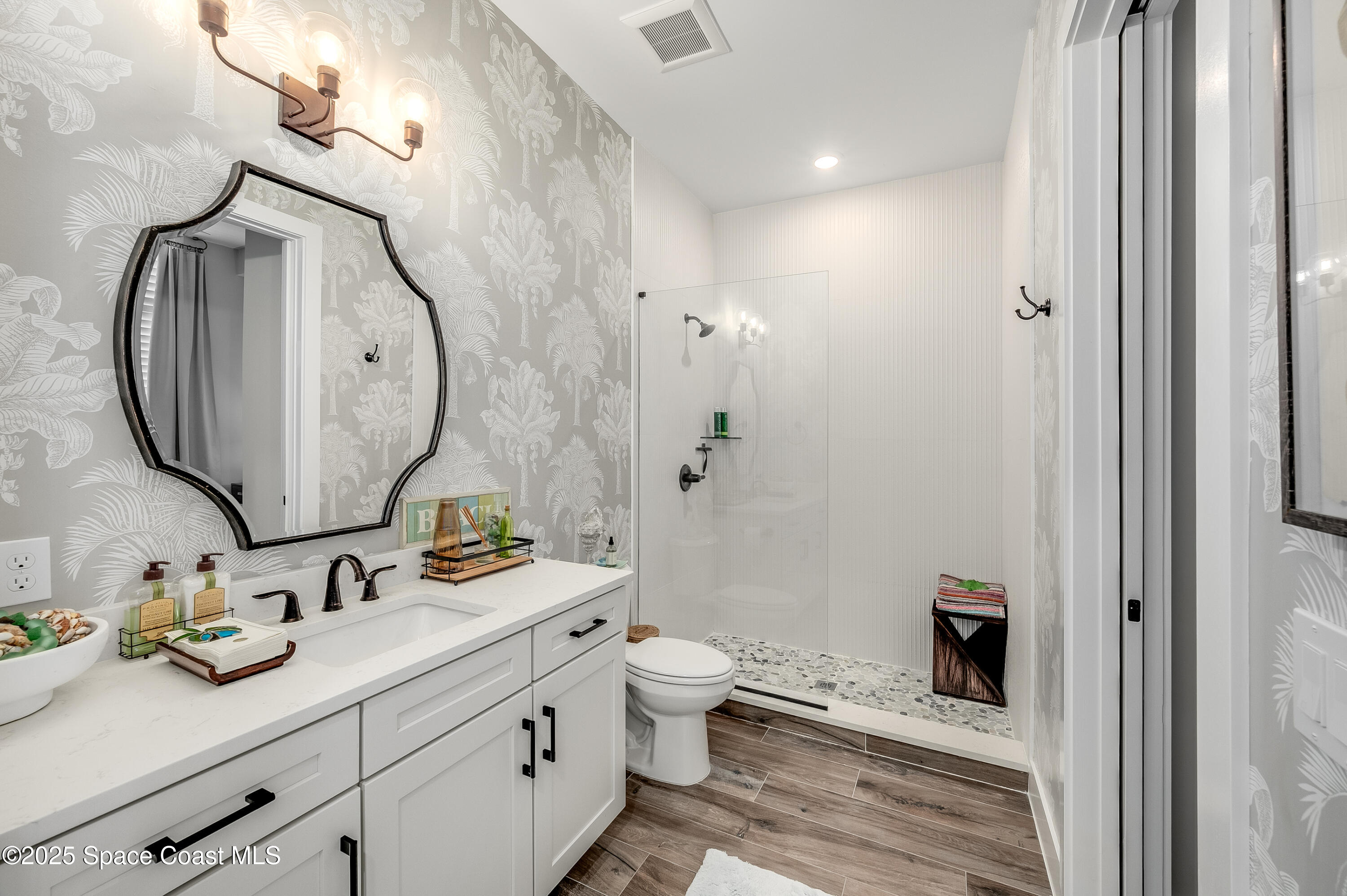 225 Strand Drive, Unit 404 Melbourne Beach, FL 32951 - Photo 13 of 51 a bathroom with a granite countertop sink mirror and toilet