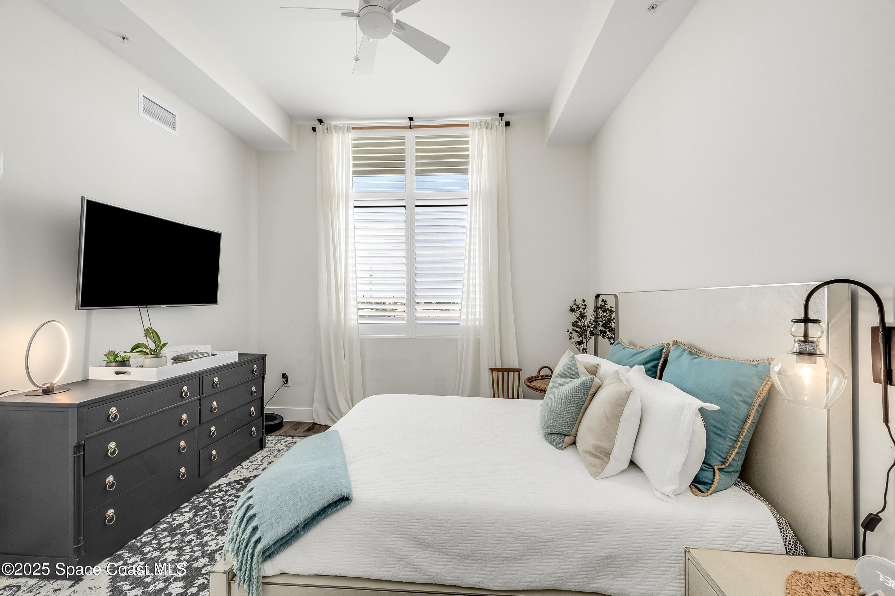 225 Strand Drive, Unit 404 Melbourne Beach, FL 32951 - Photo 15 of 51 a bedroom with a bed and a flat screen tv