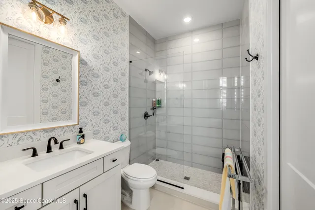 a bathroom with a bathtub shower sink vanity and toilet