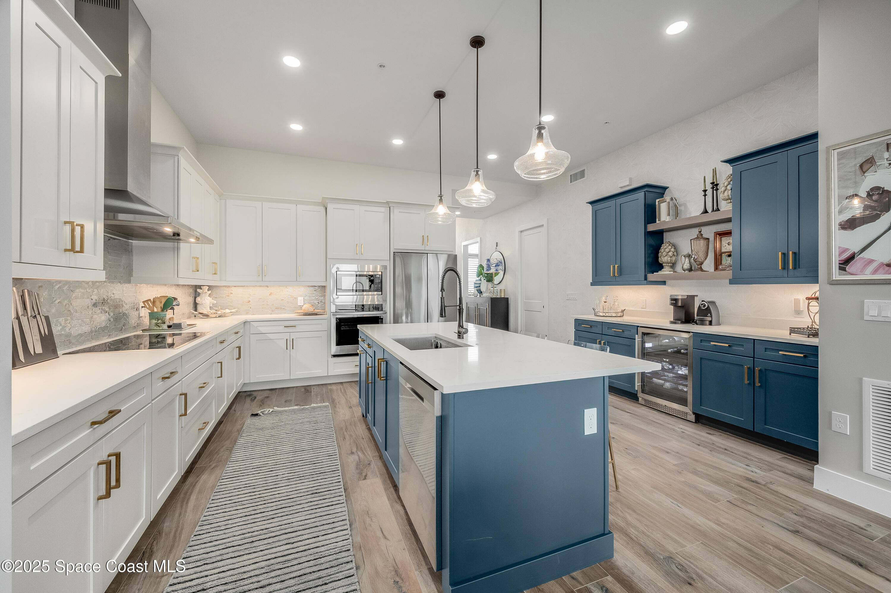 225 Strand Drive, Unit 404 Melbourne Beach, FL 32951 - Photo 29 of 51 a large kitchen with stainless steel appliances kitchen island a large island in the center and a sink
