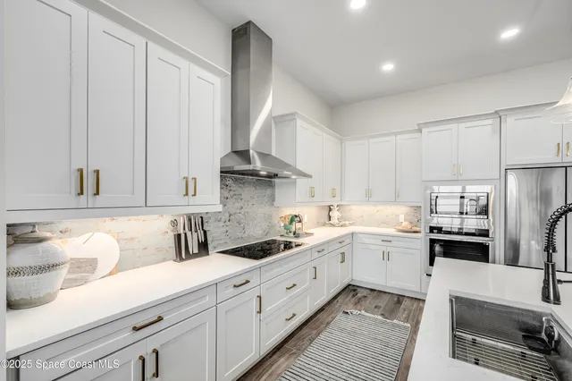 a kitchen with white cabinets and stainless steel appliances