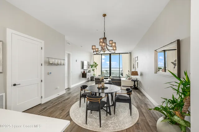a dining room with furniture a chandelier and wooden floor