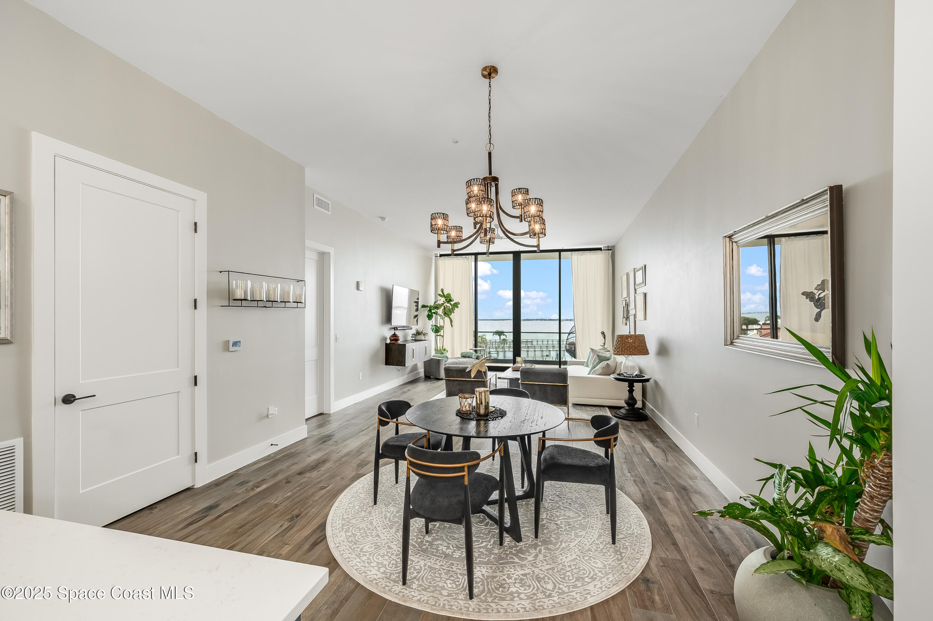 225 Strand Drive, Unit 404 Melbourne Beach, FL 32951 - Photo 33 of 51 a dining room with furniture a chandelier and wooden floor