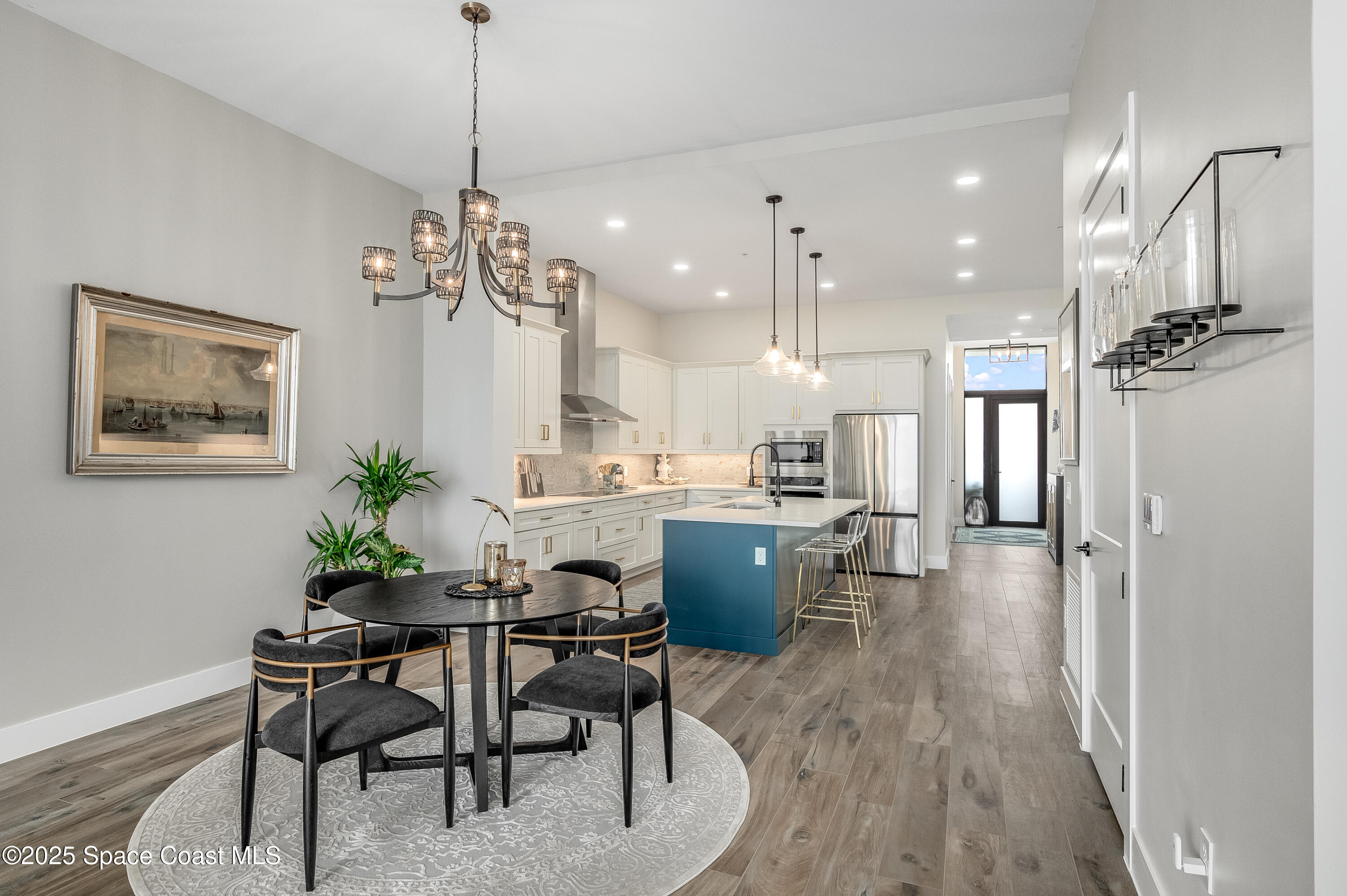 225 Strand Drive, Unit 404 Melbourne Beach, FL 32951 - Photo 34 of 51 a dining room with kitchen island stainless steel appliances furniture a chandelier and a view of kitchen