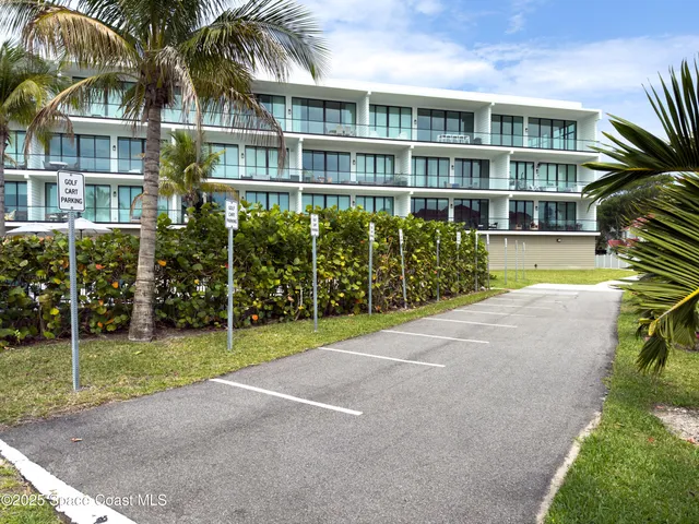 a view of a house with a yard and potted plants