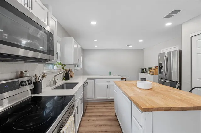a kitchen with a sink stove and cabinets