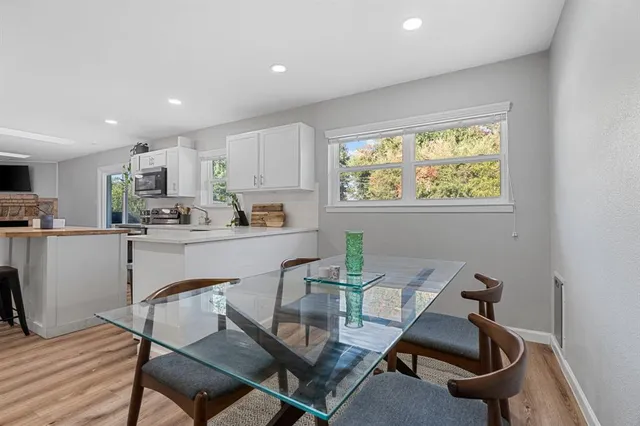 a kitchen with a dining table chairs and window