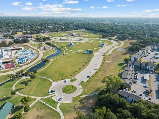 an aerial view of a swimming pool with outdoor seating and yard