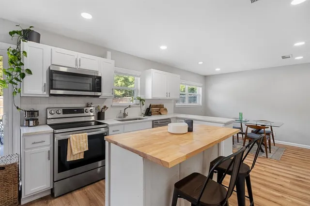 a kitchen with a stove a microwave a dining table and chairs