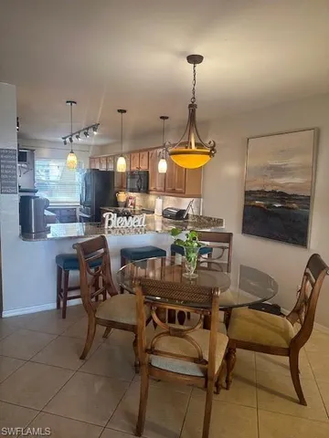 a kitchen with kitchen island granite countertop a stove a sink a dining table and chairs with wooden floor