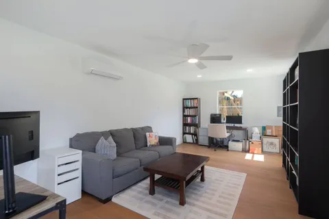 a living room with furniture and a book shelf