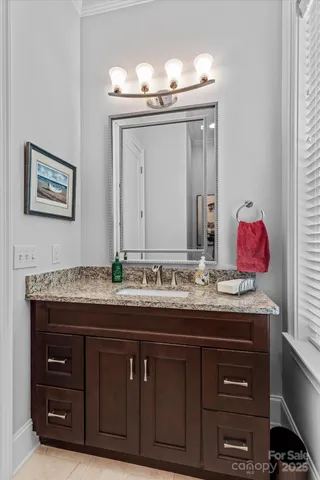 a bathroom with a granite countertop sink and a mirror