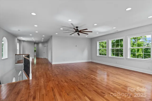 a view of a livingroom with a ceiling fan furniture and wooden floor