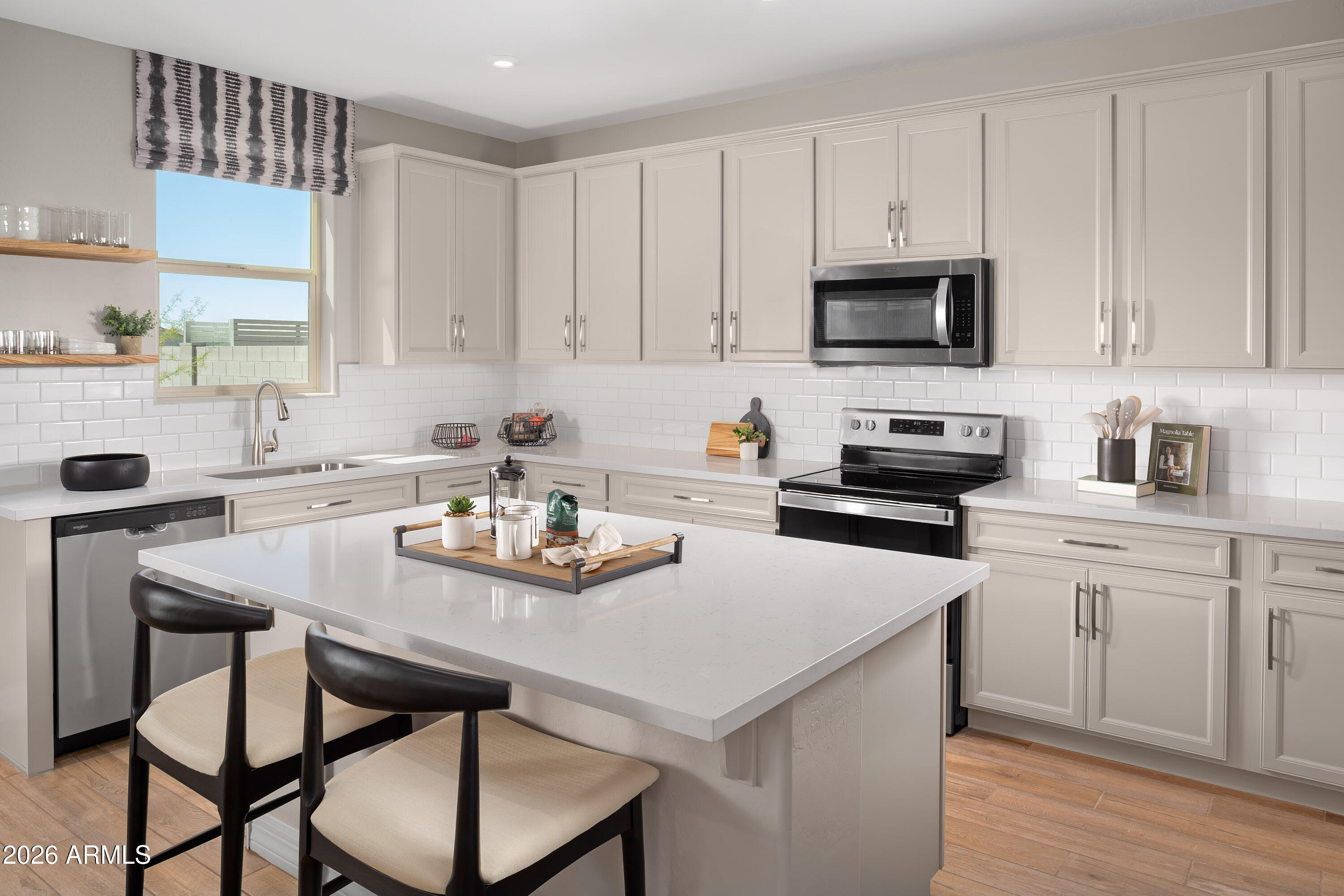 18828 North Ponte Road Maricopa, AZ 85138 - Photo 3 of 25 a kitchen with stainless steel appliances a table chairs microwave and cabinets