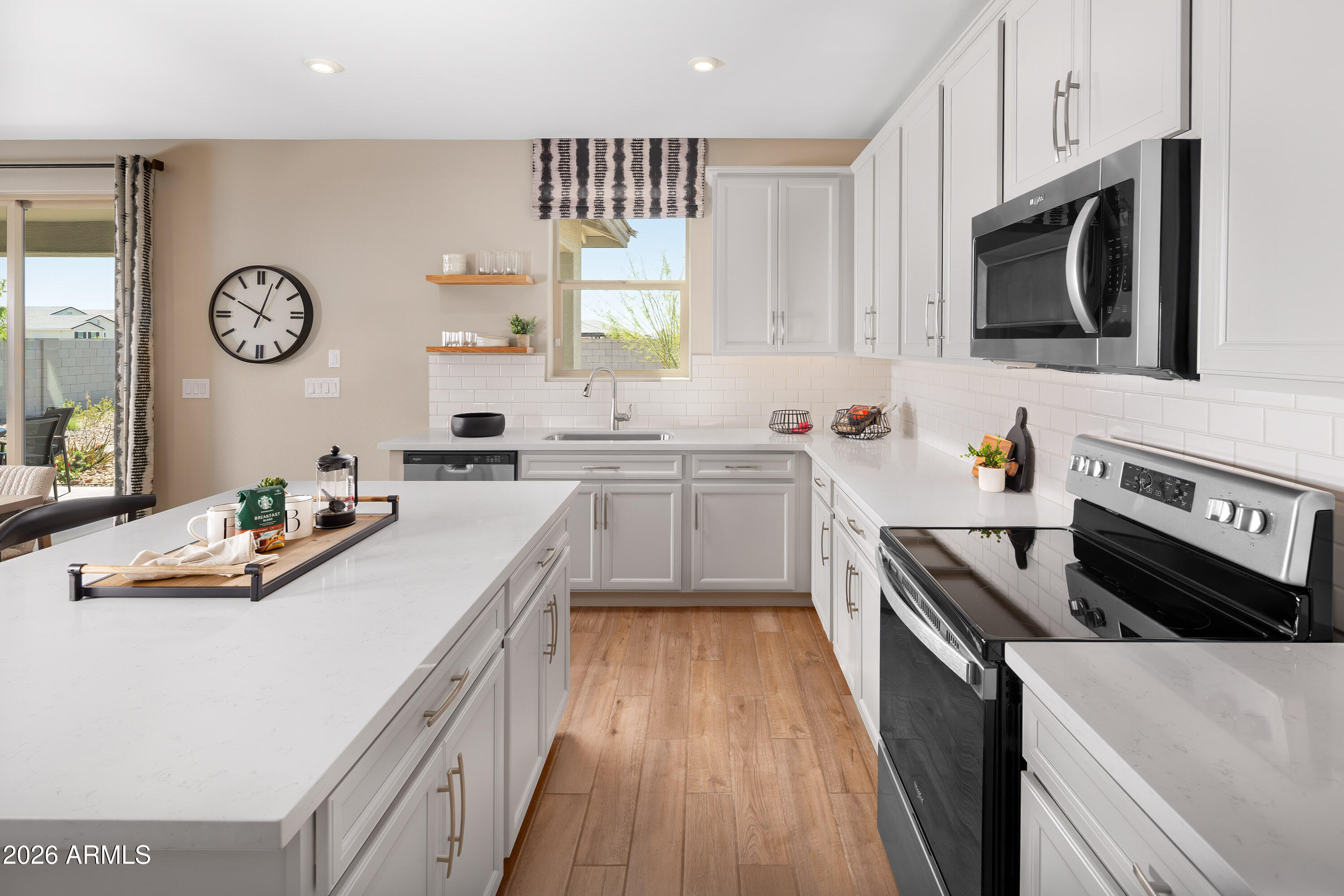 18828 North Ponte Road Maricopa, AZ 85138 - Photo 5 of 25 a kitchen with stainless steel appliances a stove a sink and a microwave